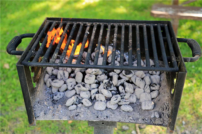 Горящий древесный уголь на открытом гриле барбекю